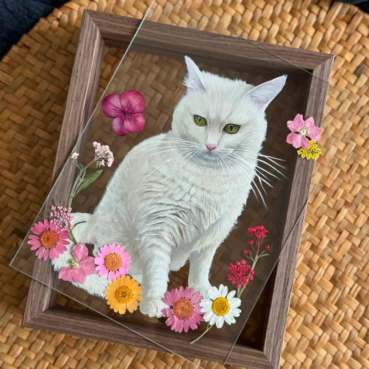 A white cat portrait with small pink and yellow flowers.
