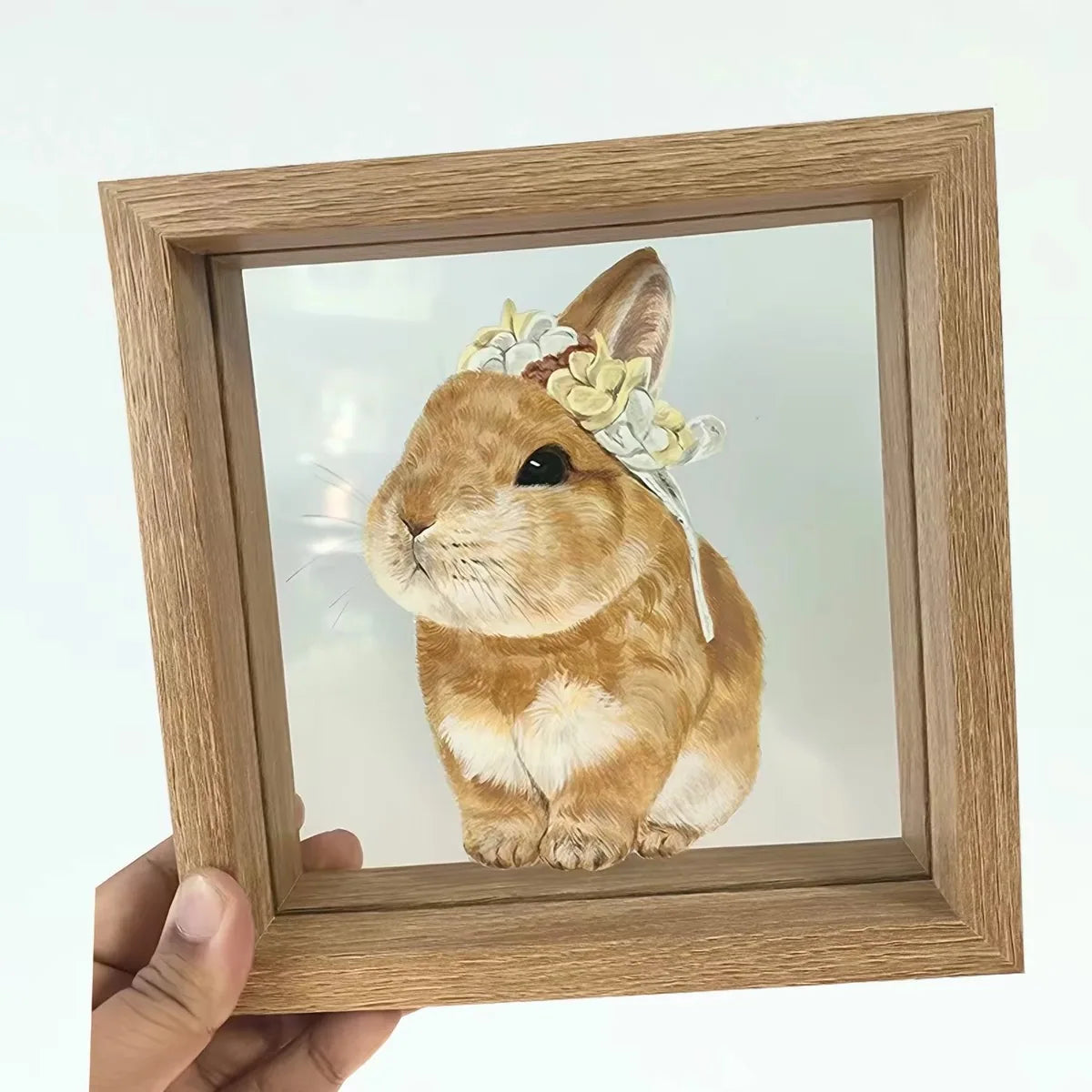 Handheld rabbit frame against plain background.