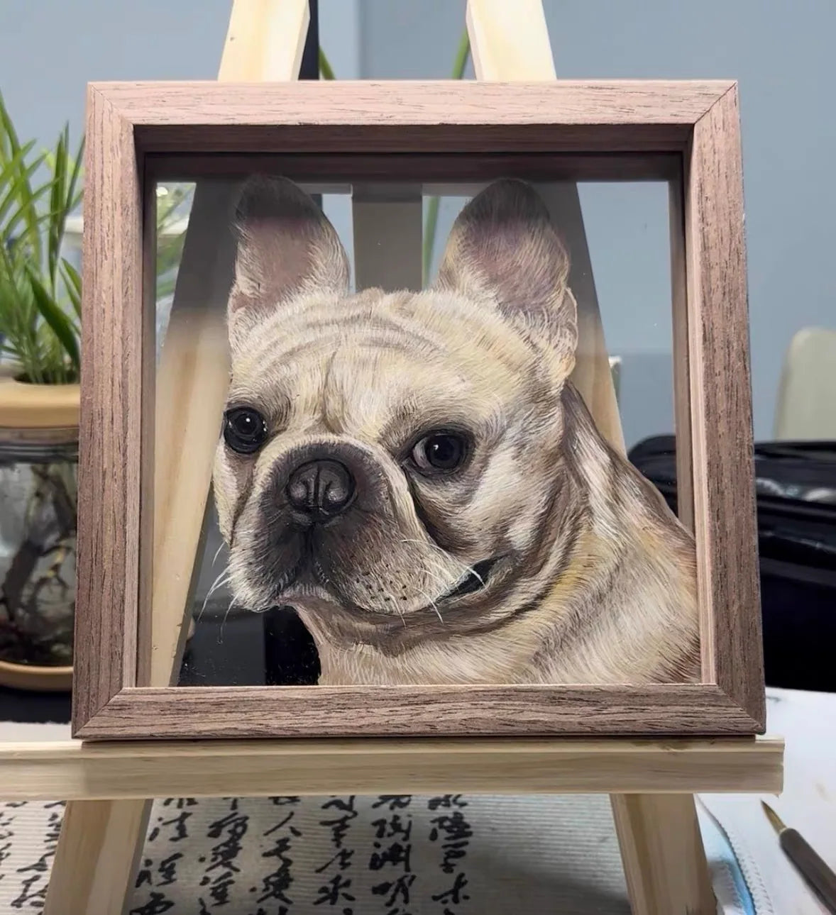 Frenchie frame on artist easel over desk paper.