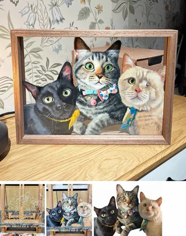 A black cat, a tabby and a cream cat together in one wooden frame.