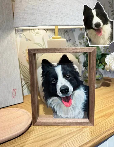 A framed black-and-white dog portrait on a wooden table.