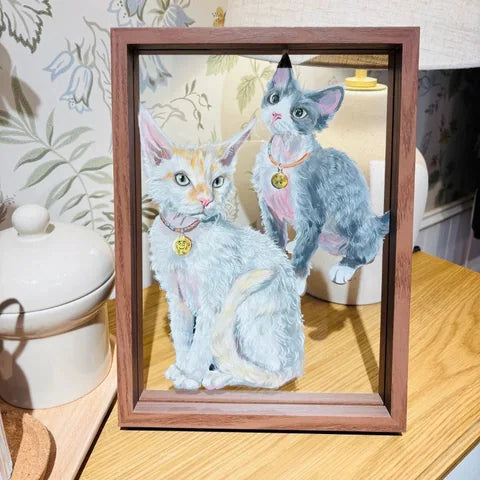 Two-cat frame on wooden table with arranged background.